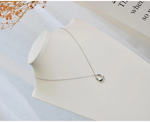 Detail of silver hollow teardrop pendant on a fine chain shown on a neck display