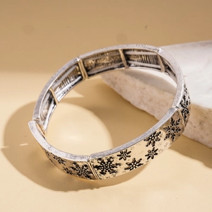 Détail du bracelet élastique argenté vintage avec gravures de flocons de neige précises