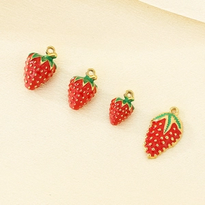 Detailed view of four 304 stainless steel gold strawberry pendants with red enamel