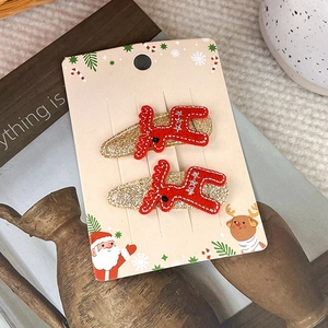 Nahaufnahme von roten Rentier-Haarspangen mit Goldglitzer auf Weihnachts-Verpackung