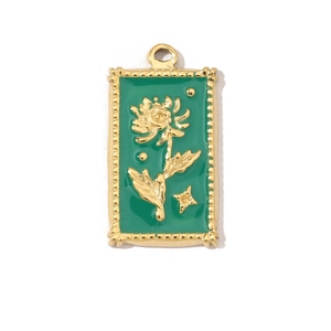 Detailed close-up of a golden rectangular pendant with green enamel and daisy flower motif
