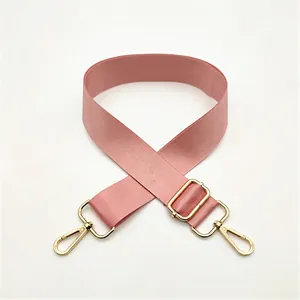 Detailed close-up of pink nylon shoulder strap with gold-tone metal hooks and adjustable buckle