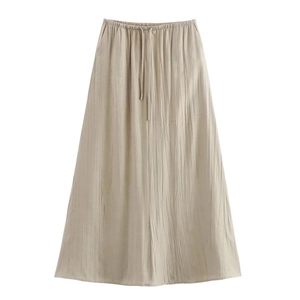 Détail d'une jupe longue plissée beige avec cordon de serrage et taille élastique