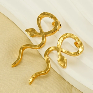 Boucles d'oreilles serpent luxueuses en acier titane doré sur fond d'exposition or et blanc