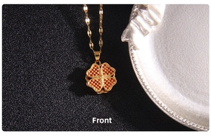 Macro shot of rotating gold clover pendant with inlaid orange zircon crystals