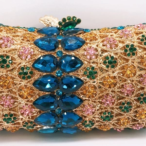 Macro detail of gold metal hollow evening bag with multicolored rhinestones and gems