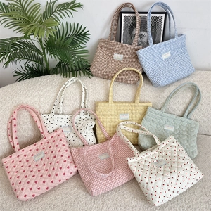 Détail de sacs fourre-tout matelassés avec motifs de cœurs et carreaux colorés