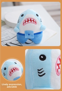 Detail of embroidered shark plush keychain with blue pocket and soft white teeth
