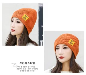 Detailed views of bright orange knit beanie with cuffed brim and side brand label