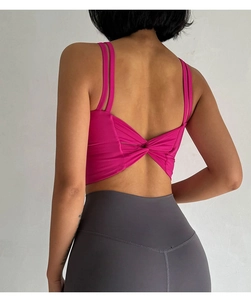 Detail of high-impact sports bra featuring double straps and back twist knot in rose red