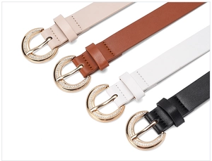 Detail of four thin elegant leather belts in beige, brown, white, and black with rhinestone buckles