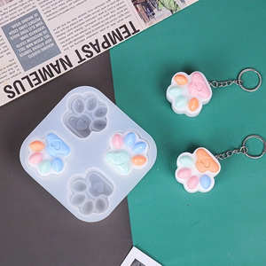 Detailed view of cat paw silicone mold with finished heart-shaped resin keychains