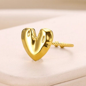 Detail shot of golden heart ring featuring twisted rope texture and embossed pattern surface