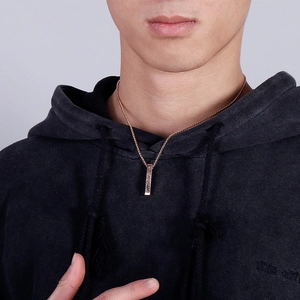 Men's titanium steel square bar pendant necklace in rose gold worn on a black hoodie