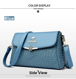 Blue woven texture crossbody bag with gold floral metal clasp and kangaroo logo detail
