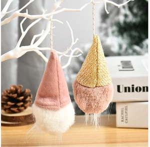 Close-up of plush faceless gnome ornaments hanging on white branches in a festive scene