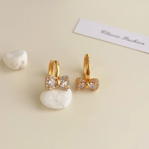 Close-up of 18K gold plated bow earrings with a crystal center and pavé accents