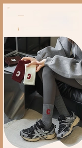Détail de la broderie de la lettre 'C' sur des chaussettes en coton premium gris doux