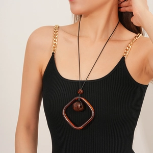 Detailed view of amber square pendant necklace with wax rope worn by a fashion model
