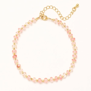 Vue détaillée des perles roses et des séparateurs dorés sur le bracelet de style bohème
