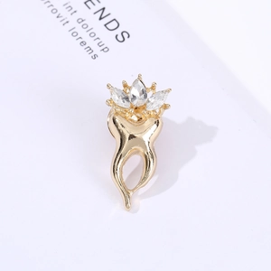 Macro shot of creative tooth shaped brooch with polished gold plating and sparkling crystals