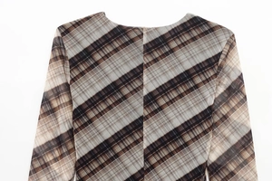 Detailed view of plaid pattern fabric with central seam on a slim fit mesh dress