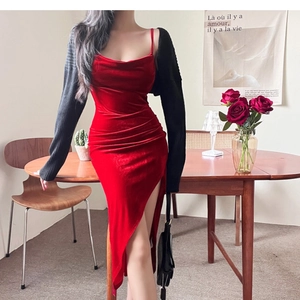 Detail of red velvet slit dress paired with black knit shawl and chic shoulder bag