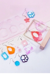 Detailed view of translucent silicone molds and colorful DIY resin jewelry with glitter