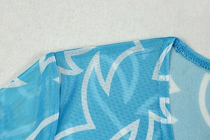 Détails de l'imprimé géométrique bleu et blanc sur tissu mesh avec couture du col en V