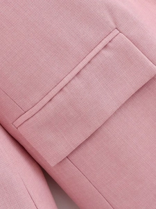 Close-up of the pocket tailoring and woven fabric texture on a pink casual blazer