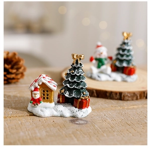 Macro shot of resin Christmas tree and Santa figurines with a warm bokeh background