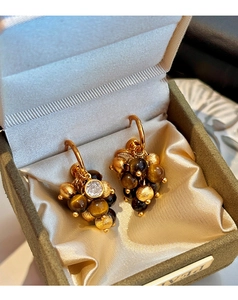 Detailed view of grape-shaped tiger eye stone earrings with matte gold beads and rhinestones