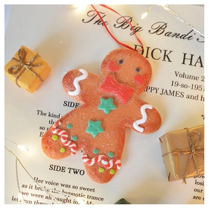 Detail of gingerbread man Christmas tree ornament with festive red and gold background