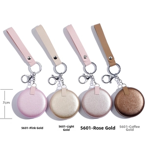 Set of four 7cm circular metallic keychains with leather straps in varied gold tones