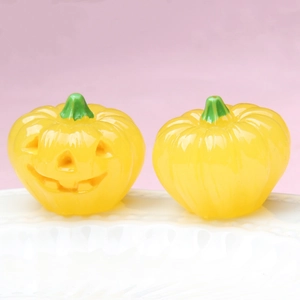 Close-up of dual glowing Halloween pumpkins with Jack-O-Lantern face on a white tray