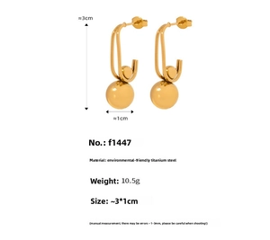 Detail of gold-plated titanium steel U-shaped earrings with solid bead pendant