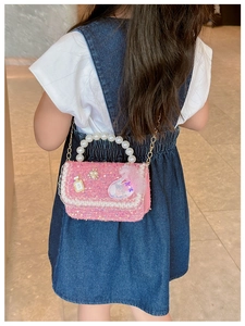 Rear view of a girl wearing a pink tweed shoulder bag with pearls and sequins