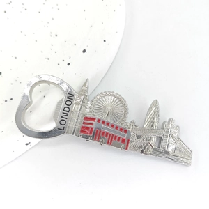 Close-up of London skyline metal bottle opener with red bus detail on a ceramic plate