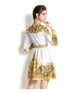 Detail des weißen V-Ausschnitt-Kleides mit gelbem Paisley-Print und eleganten Rüschenschultern