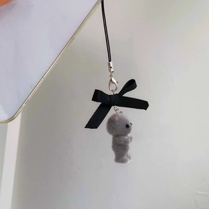 Close-up of grey flocked cat charm with black ribbon bow and silver lobster clasp