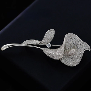 Macro shot of Calla Lily brooch featuring silver pave-set crystals and central zircon
