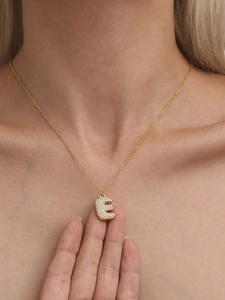 Close-up of gold stainless steel necklace featuring a zircon encrusted letter E pendant