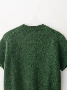 Dettaglio del maglione in mohair verde bosco con morbida trama e girocollo a costine