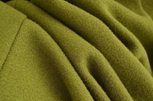 Dettaglio della trama del tessuto in lana verde oliva per eleganti cappotti invernali