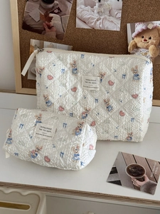 Set of two quilted makeup bags featuring blue rabbit print and heart patterns