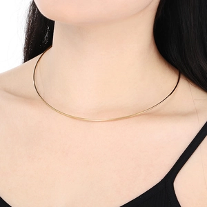 Close-up of minimalist thin golden choker wire necklace on model's neck and collarbone