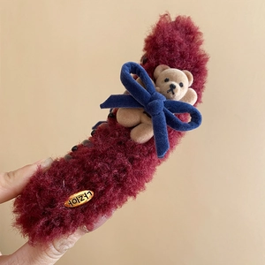 Detail of burgundy plush hair claw with blue velvet bow and small teddy bear ornament