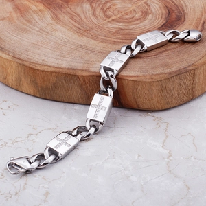 Détail du bracelet gourmette argenté de style hip-hop avec croix sertie de brillants
