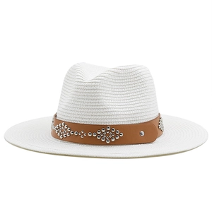 White straw cowboy hat with brown leather band and silver studs on white background