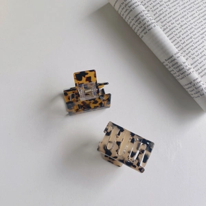 Detail shot of tortoiseshell pattern acetate hair claw clip with silver metal spring